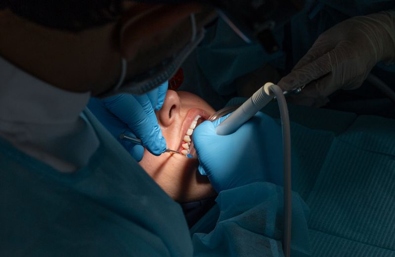 Oral surgeon and assistant performing a surgical procedure on a patient